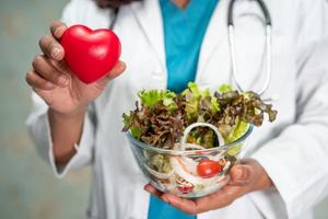 Nutritionist doctor holding various healthy fresh vegetables photo