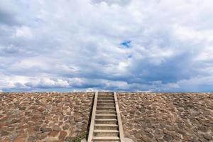 The stairway to the dam is filled with stone on the background photo