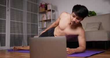 Man Using Laptop and Doing Side Planks video
