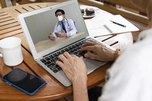 senior woman consult asian doctor via video call photo