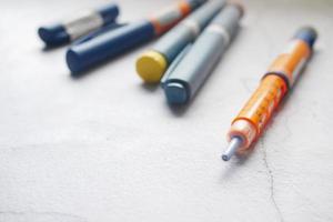 Insulin pens on wooden background, close up photo