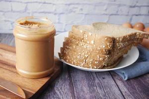 peanut butter and stack of bread on table photo