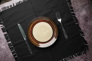 cutlery and empty plate on wooden background top down photo