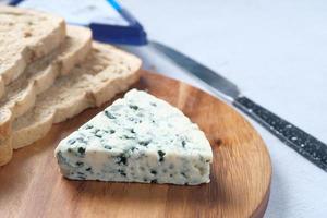 blue cheese ,and slice of brown bread on table