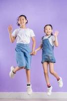 Portrait of two Asian girls on purple background photo