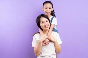 retrato, de, asiático, madre e hija, en, fondo púrpura foto