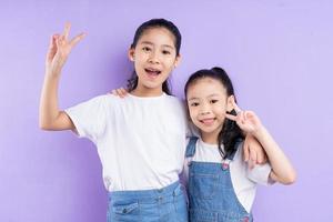 Portrait of two Asian girls on purple background photo