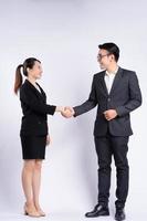 Asian businessman and businesswoman shaking hand on white background photo