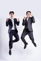 Two Asian businessmen jumping on white background photo