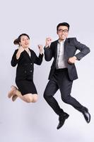 Businessman and business woman jumping on white background photo
