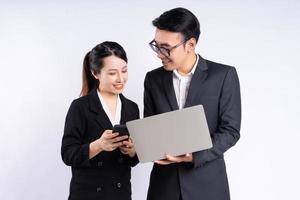 Asian businessman and businesswoman using laptop on white background photo