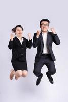 Businessman and business woman jumping on white background photo