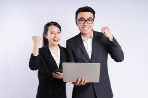 Asian businessman and businesswoman using laptop on white background