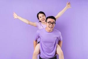 Young Asian couple posing on purple background photo