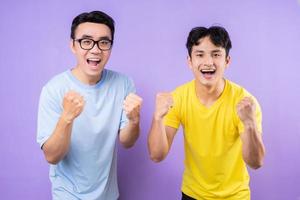 dos hermanos asiáticos posando sobre fondo púrpura foto