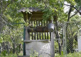 well with iron bucket on long forged chain for clean drinking water photo