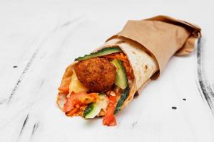 Bread pita with falafel and vegetables on the kitchen table photo