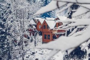 Wooden cottage house in mountain covered with fresh snow in winter photo