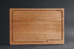 Wooden cutting board on black background photo