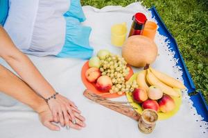 Pareja joven comiendo uvas y disfrutando de un picnic foto