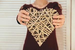 Decorative wicker heart in the hands of a woman photo