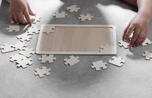 Asian little boy playing wooden jigsaw puzzle photo