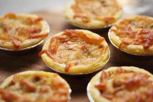 Mini pie from meat and mushrooms in wooden tray photo