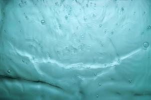 texture of splashing water on turquoise background photo