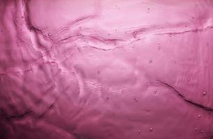 textura de salpicaduras de agua sobre fondo rosa foto