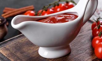salsa roja o kétchup en un bol e ingredientes para cocinar