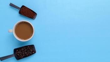 Coffee mug, coffee beans, ground coffee on a blue background photo