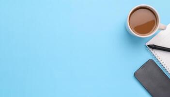 Electronic pen, smartphone, book, coffee mug on blue background. photo