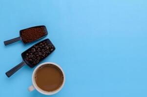 Coffee mug, coffee beans, ground coffee on a blue background photo