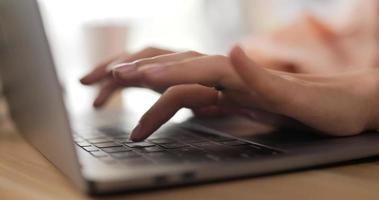 vista lateral de mãos femininas digitando em um laptop