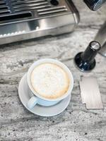 freshly prepared cappuccino in cup with saucer photo