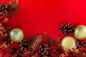 Festive composition of cones and Christmas balls on red background photo