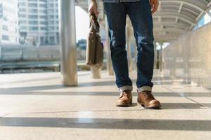 Man walking in the city and holding Laptop bag photo