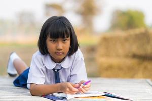 Asian student in uniform studying at countryside of Thailand photo