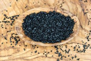 Black salt from Hawaii on olive wood photo