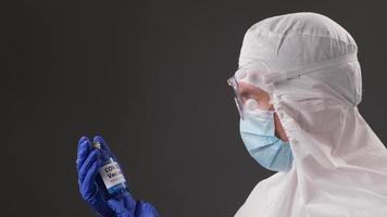 el desarrollador de la vacuna contra el coronavirus sostiene una ampolla transparente. el médico examina la nueva vacuna. pandemia de covid 19 foto