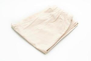 Pantalón beige doblado aislado sobre fondo blanco. foto