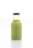 Matcha green tea latte in glass bottle on the table photo