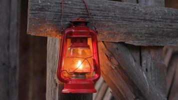 Cerca de la lámpara de queroseno rojo en la pared de madera