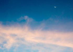 Crescent moon and clouds in the sky photo