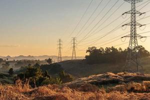 High voltage transmission tower at sunset photo