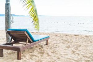 Silla de playa, palmeras y playa tropical en Pattaya en Tailandia foto