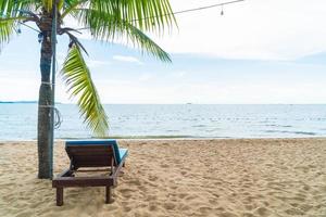 Silla de playa, palmeras y playa tropical en Pattaya en Tailandia foto