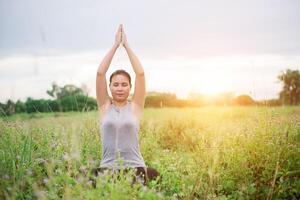 Beautiful yoga woman practicing yoga at meadows. photo