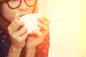 hermosa joven con gafas bebiendo café en la caf foto