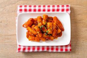 Korean rice cake stick with sausage in spicy sauce - Tteokbokki photo